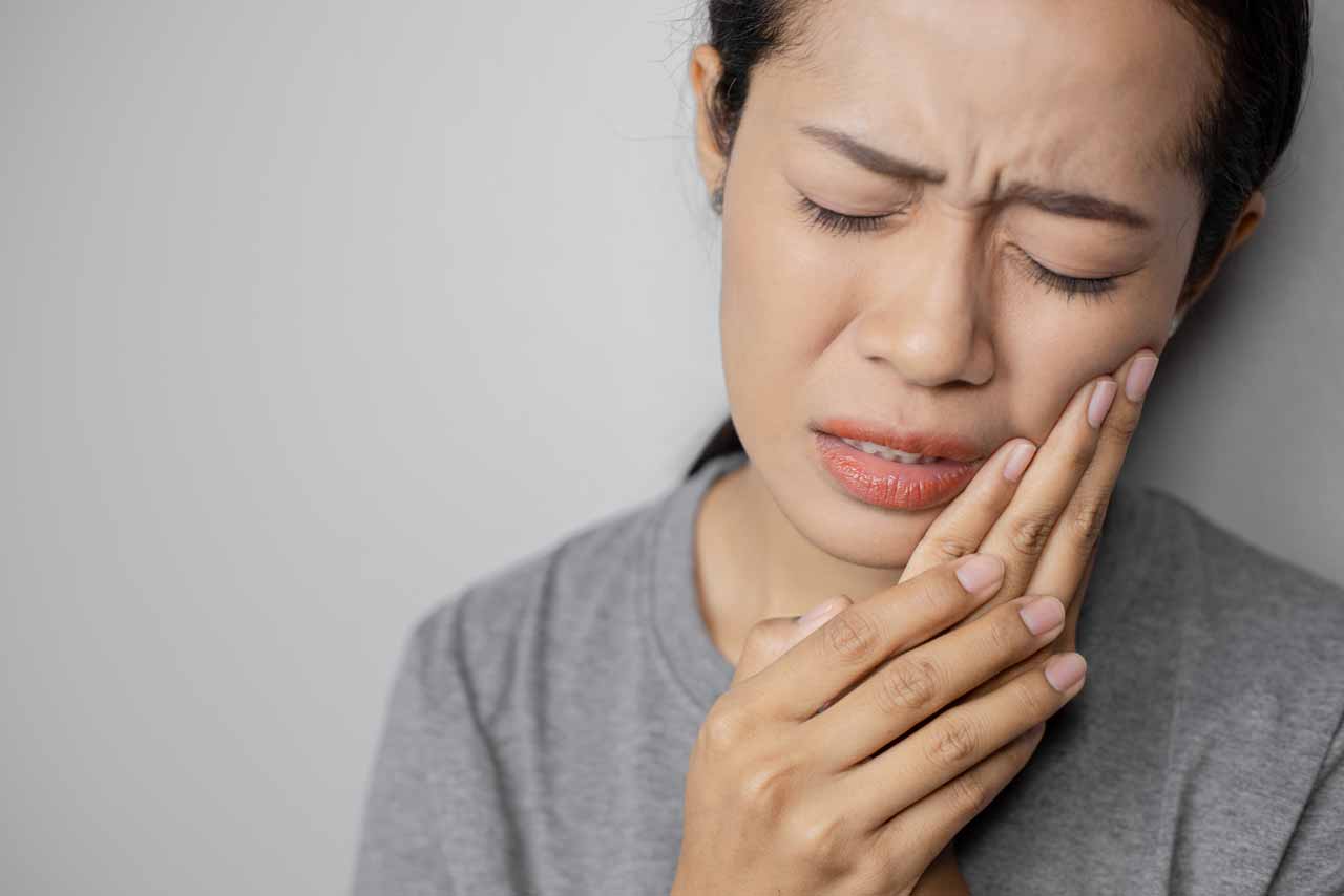 lady suffering from a bad tooth ache - in need of a wisdom tooth surgery